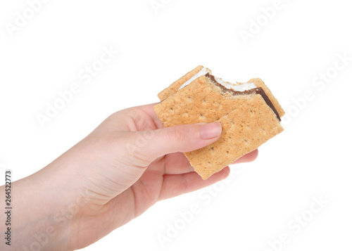 Young caucasian female hand holding s'more with bite missing, isolated on white background photo