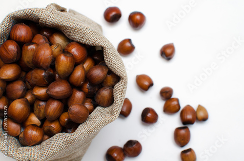 Hazelnuts, filbert in burlap sack on white background.. heap or stack of hazelnuts