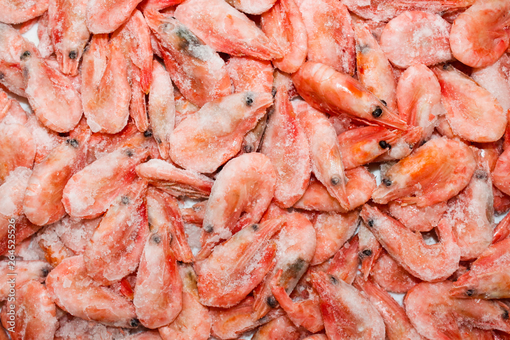 Raw shrimp background. Pile of frozen shrimps on white background.Close-up of frozen shrimps. Shrimp and ice, top view. Raw shrimp background. Pile of frozen shrimps on white background.Close-up of frozen shrimps. Shrimp and ice, top view.