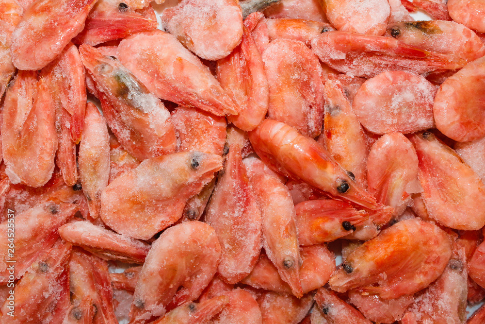 Raw shrimp background. Pile of frozen shrimps on white background.Close-up of frozen shrimps. Shrimp and ice, top view. Raw shrimp background. Pile of frozen shrimps on white background.Close-up of frozen shrimps. Shrimp and ice, top view.