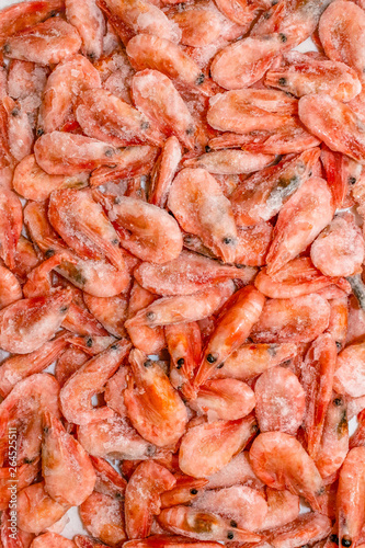 Raw shrimp background. Pile of frozen shrimps on white background.Close-up of frozen shrimps. Shrimp and ice, top view.
