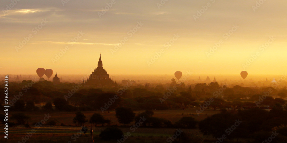 Sunset in buddhist temple,stupa,in the historical park of Bagan,Myanmar with air balloon in the sky