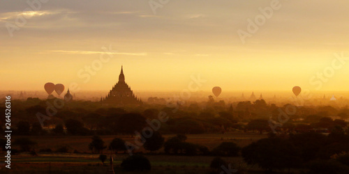 Sunset in buddhist temple stupa in the historical park of Bagan Myanmar with air balloon in the sky