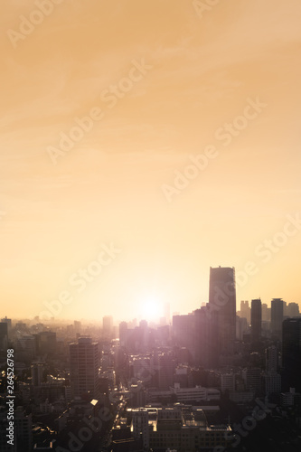 Aerial view of a city skyline at sunset with haze  Vertical image with logos and trademarks cloned out.