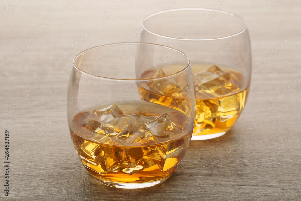Two glasses with whiskey with ice cubes Two glasses with whiskey with ice cubes