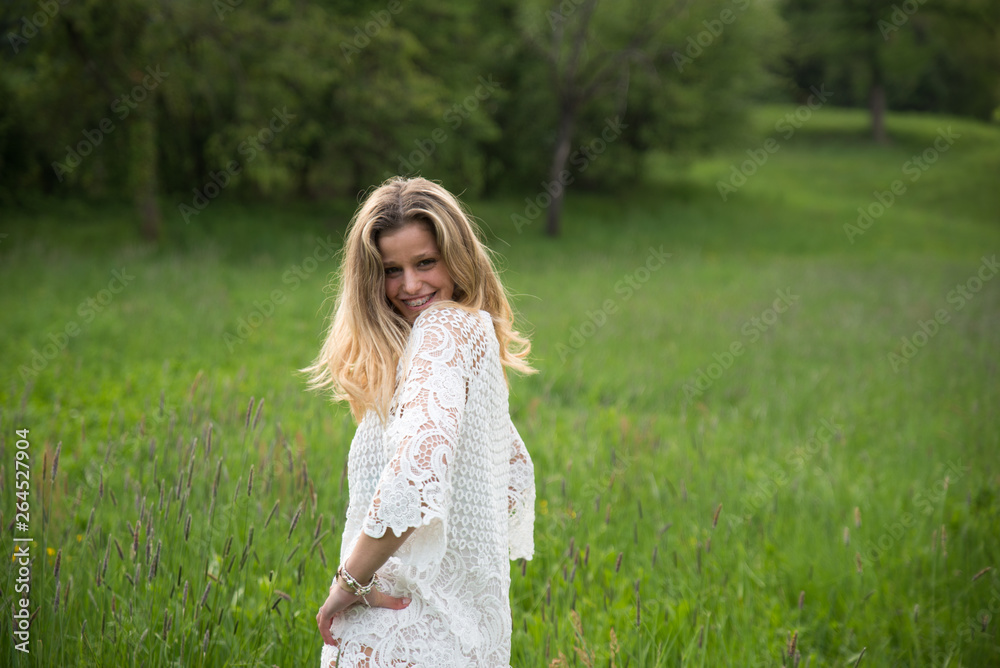 Young happy caucasian woman smiling in a meadow full of flowers. Nature and happiness concepts Young happy caucasian woman smiling in a meadow full of flowers. Nature and happiness concepts