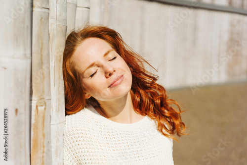 Young redhead woman soaking up the sun