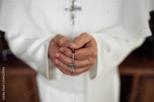 Hands of an papa holding rosary beads photo