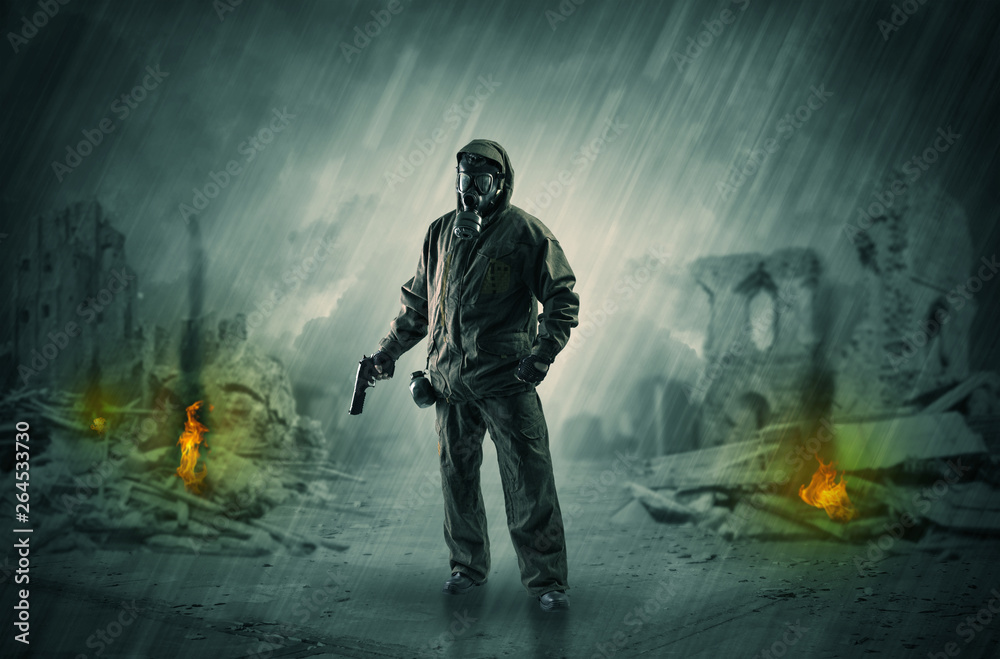 Fototapeta premium Destroyed place after a catastrophe with man in gas mask and weapon on his hand 