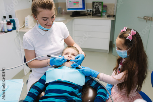 Little girl help female dentist  new teeth examinationand treatment of cavities