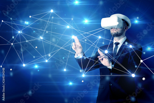 Businessman in virtual reality goggles investigate global network connectivity concept   © ra2 studio