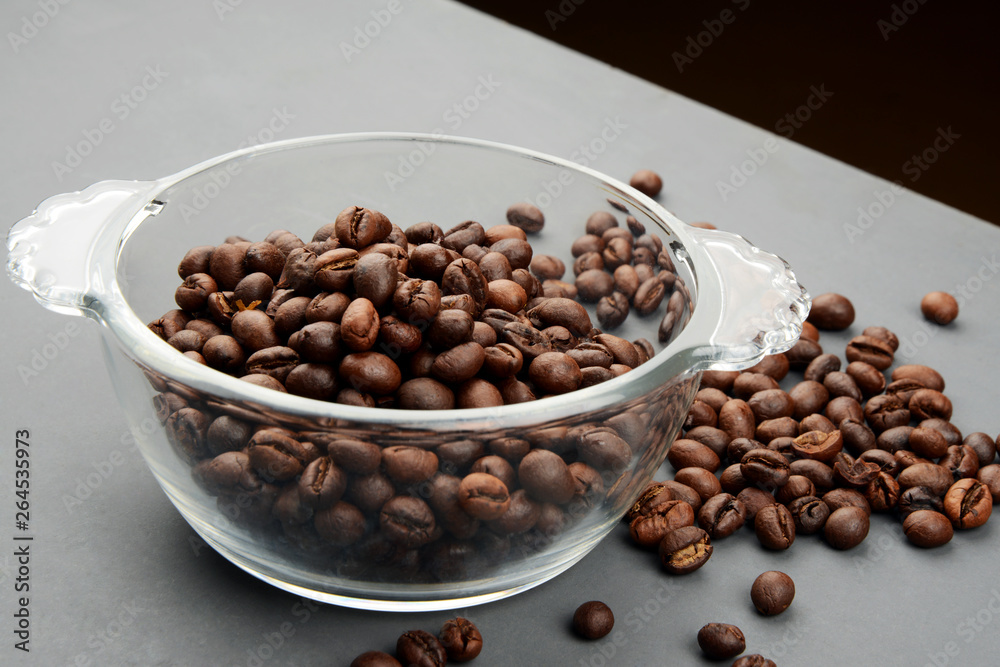 Roasted Coffee beans in a bowl on grey background