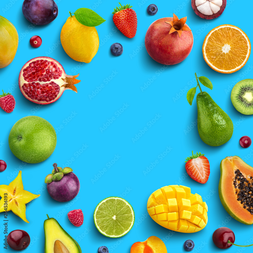 Various fruits and berries isolated on blue background, top view, creative flat layout, round frame of fruits with empty space for text