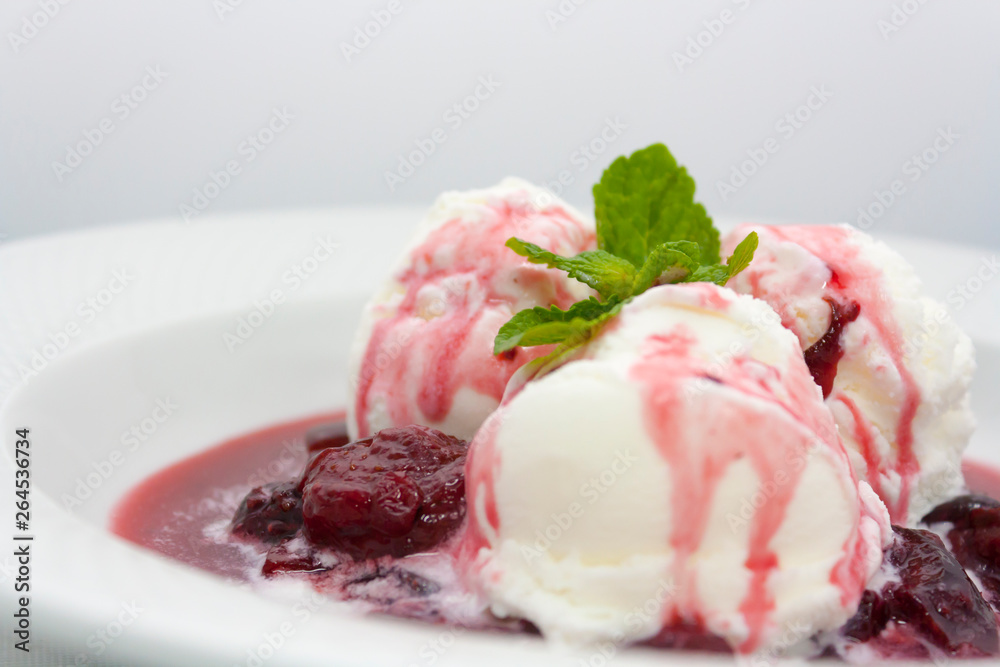 three scoops of delicious ice cream with flowing plum jam and a sprig of mint luxury class on a white background in the restaurant three scoops of delicious ice cream with flowing plum jam and a sprig of mint luxury class on a white background in the restaurant
