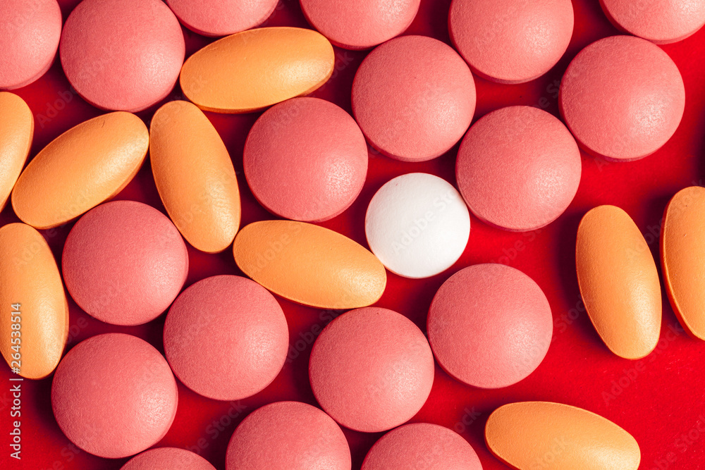 Many medicine pills close up on red background Many medicine pills close up on red background