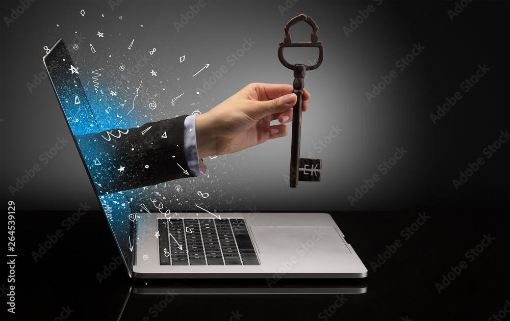 Hand with huge vintage key coming out of a laptop with sparkling