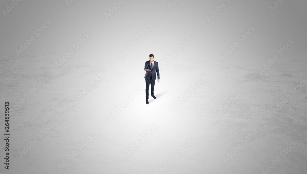 Young businessman standing alone in the middle of an empty space
Young businessman standing alone in the middle of an empty space
