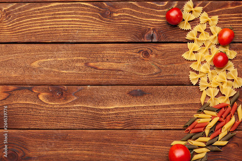Pasta and ingredients on wooden background with copy space. Top view.