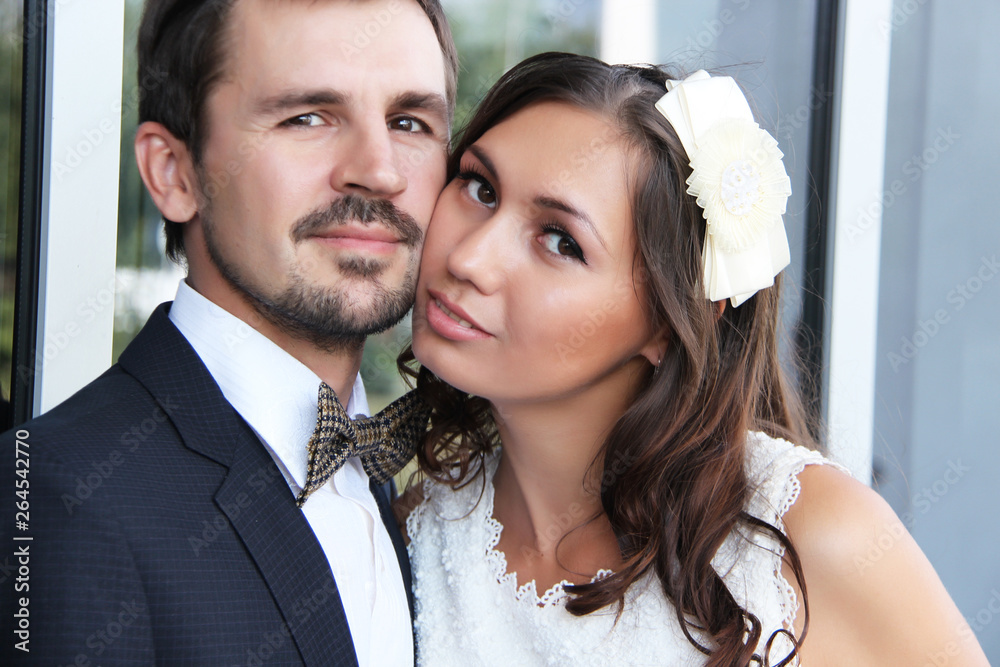 Young wedding couple enjoying romantic moments on the street near the mirror wall. Young wedding couple enjoying romantic moments on the street near the mirror wall.