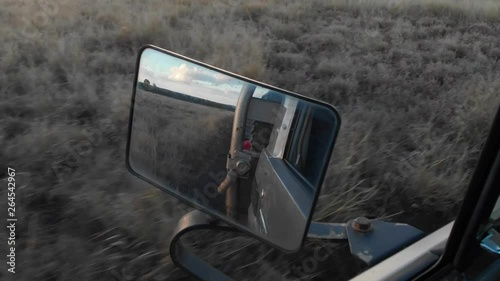 landcruiser is driving trough the outback from australia shot from inside the car mirrorview photo
