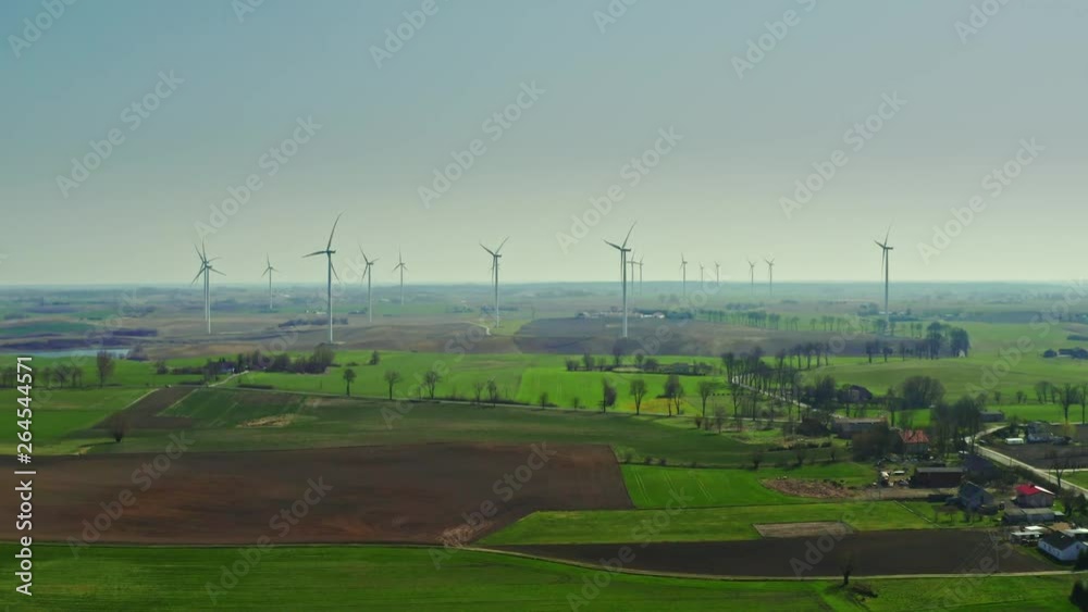 Farm of wind turbines on spring field in sunny day, Poland