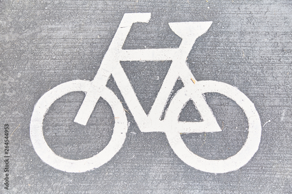 Sign of the bike path on the asphalt in the park. 
