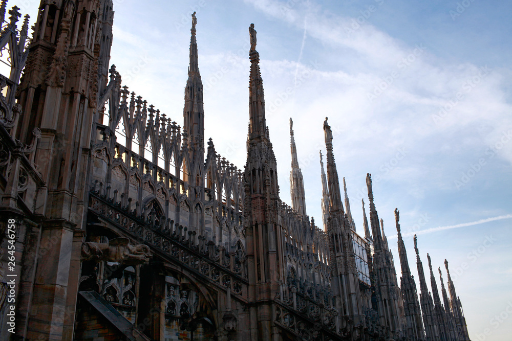 Cathedral statues of the Duomo di Milano towers against the sky above the city