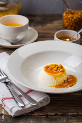 dessert pana cotta with see-buckthorn orange sauce in white plate restaurant