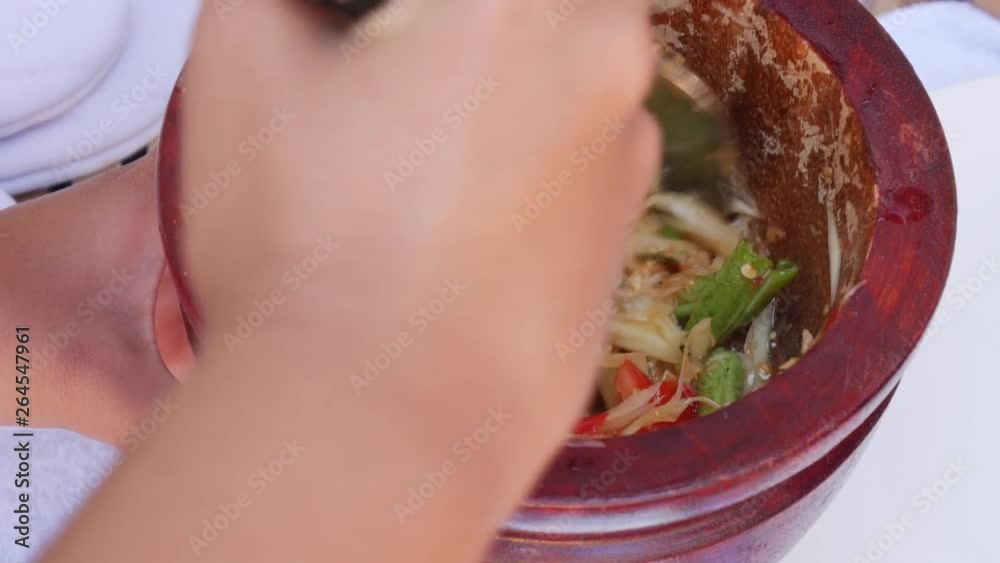 Thai womens preparing green papaya salad som tam in wooden mortar with pestle. Close Up. 4k