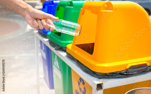 Man hand throwing plastic in recycling bin to help environmental protection and Waste separation reduce global warming.