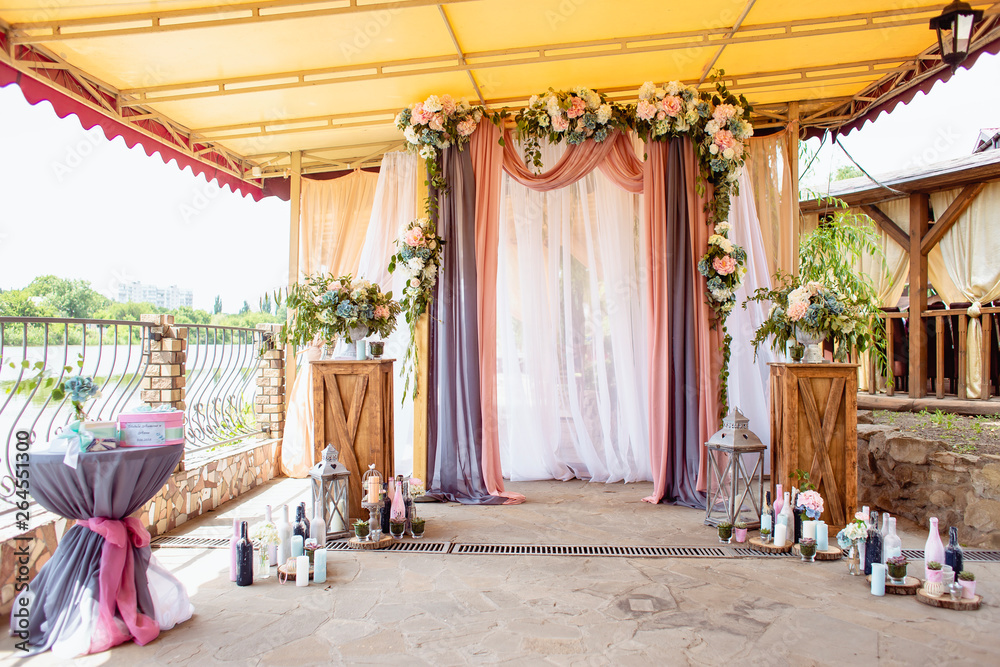 Obraz premium Wedding decoration ceremony. Arch of flowers on the summer area of the restaurant