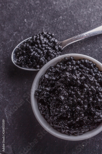 black caviar in a bowl on a dark stone background