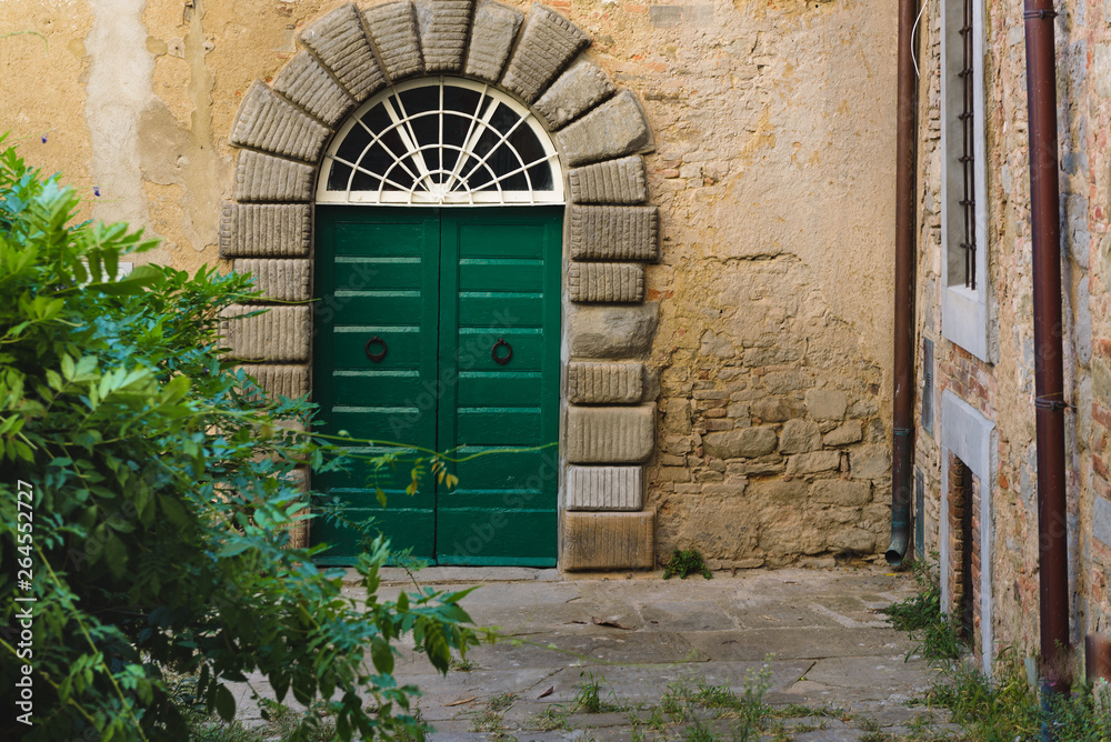 Fototapeta premium Very old door of the house in a Tuscan village.