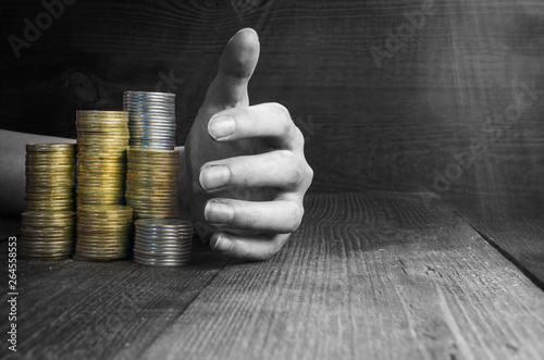 hand picks up piles of money, black and white toning