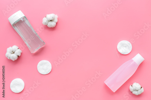 mycelial water, lotion and cotton pads for skin care on pink background flat lay space for text