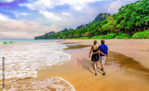Honeymoon couple enjoy walk along scenic Havelock Island sea beach Andaman, India at sunset photo