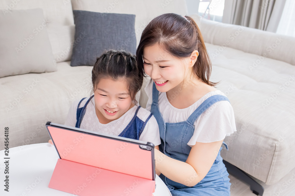 Mom and daughter use tablet happily Mom and daughter use tablet happily