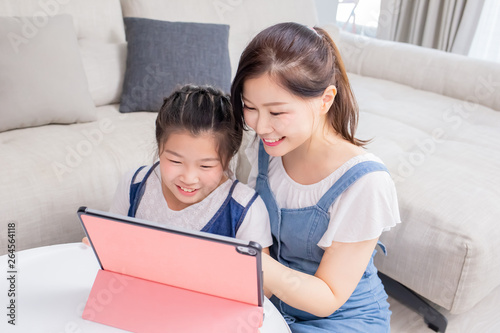 Mom and daughter use tablet happily