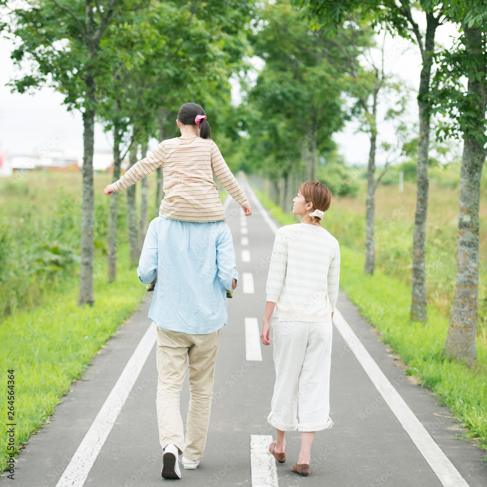 一本道で肩車をする親子の後姿 一本道で肩車をする親子の後姿
