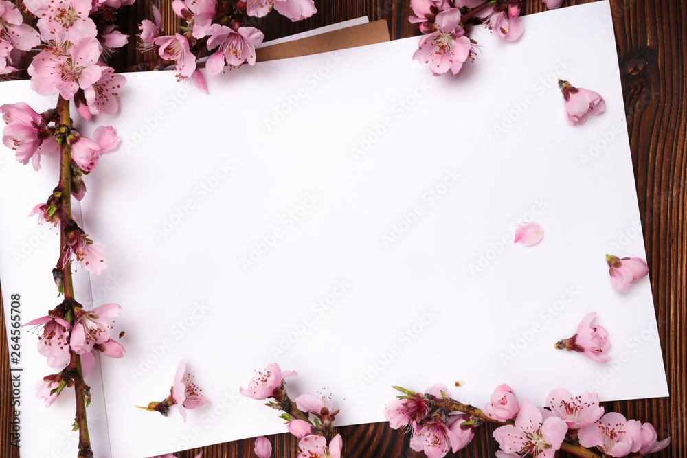 White paper sheet and sprigs of the apricot tree with flowers on wooden background. Place for text. The concept of spring came, happy easter, mother's day.Top view.Flay lay. Copy space. White paper sheet and sprigs of the apricot tree with flowers on wooden background. Place for text. The concept of spring came, happy easter, mother's day.Top view.Flay lay. Copy space.
