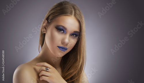 Beautiful girl model. Creative turquoise makeup and body art on a Gray background.