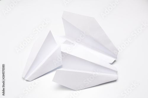 Flat lay of white paper planes on white background.