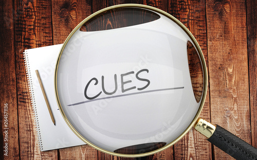 Study, learn and explore cues - pictured as a magnifying glass enlarging word cues, symbolizes analyzing, inspecting and researching the meaning of cues, 3d illustration photo