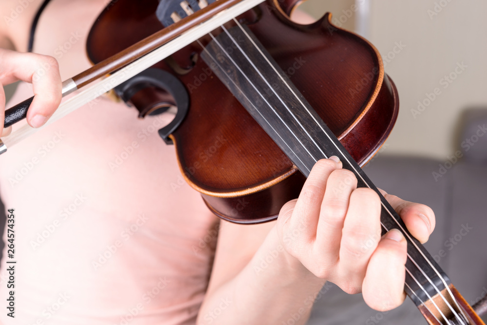 Young woman hand playing classical violin. Teen girl learning to play song Young woman hand playing classical violin. Teen girl learning to play song