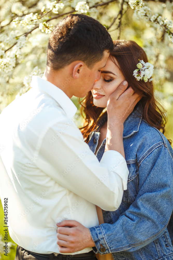 Beautiful loving couple in the blooming gardens. Wedding concept. Great sunset light. Lovely newlyweds. Beautiful loving couple in the blooming gardens. Wedding concept. Great sunset light. Lovely newlyweds.