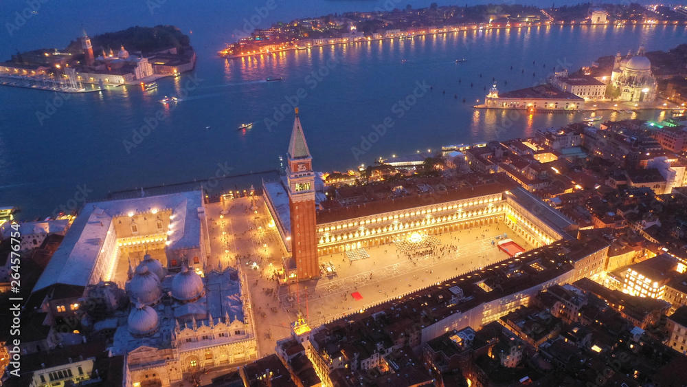 Fototapeta premium Aerial drone night shot of iconic illuminated Saint Mark's square or Piazza San Marco featuring Doge's Palace, Basilica and Campanile, Venice, Italy