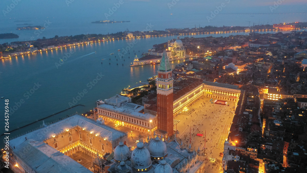 Fototapeta premium Aerial drone night shot ikonowego oświetlonego Placu Świętego Marka lub Piazza San Marco z Pałacem Dożów, Bazyliką i Campanile, Wenecja, Włochy