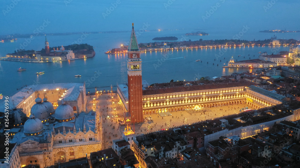 Aerial drone night shot of iconic illuminated Saint Mark's square or Piazza San Marco featuring Doge's Palace, Basilica and Campanile, Venice, Italy