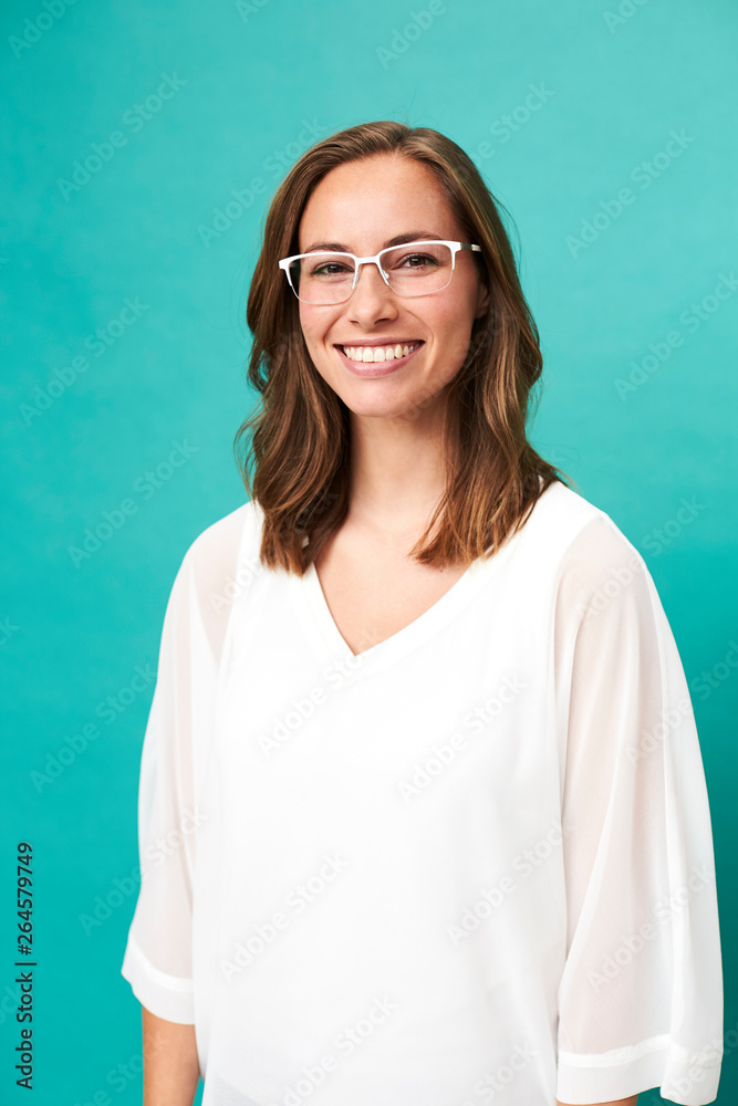 Smiling girl in glasses against blue