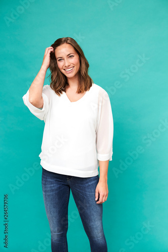 Beautiful brunette with hand in hair, smiling